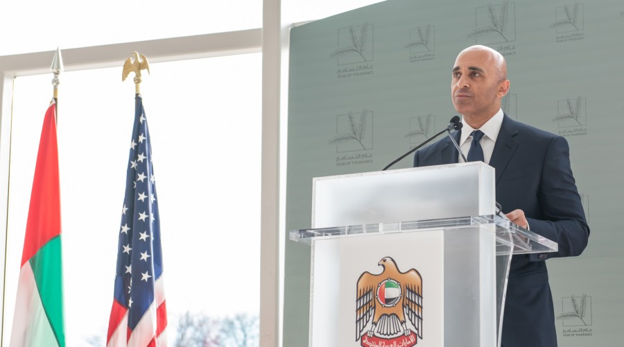 Ambassador Yousef Al Otaiba stands at a podium at the UAE Embassy with UAE and US flags to his right