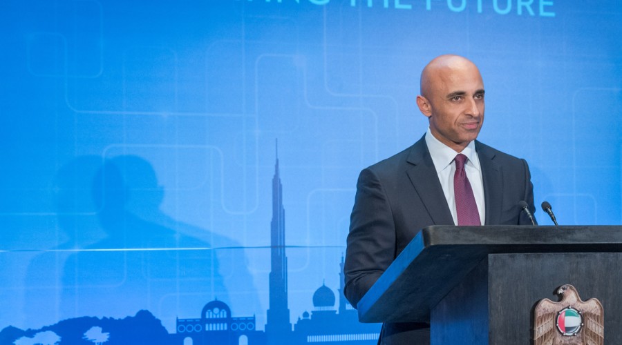 Yousef Al Otaiba stands in front of a blue screen with the words innovating the future